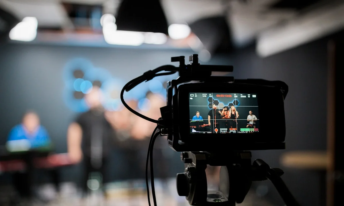 Videokamera v popředí malého studia během přípravy záběru